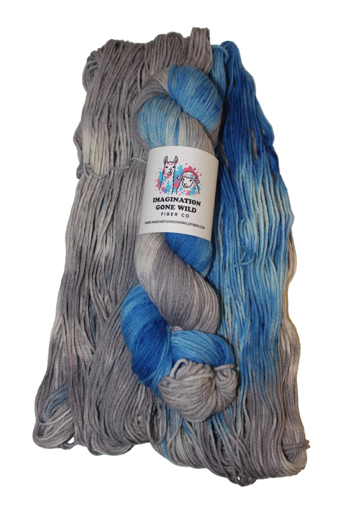 A folded skein of variegated yarn with gray, blue, and white color-shifting yarn blended together, featuring a white paper label in the center.